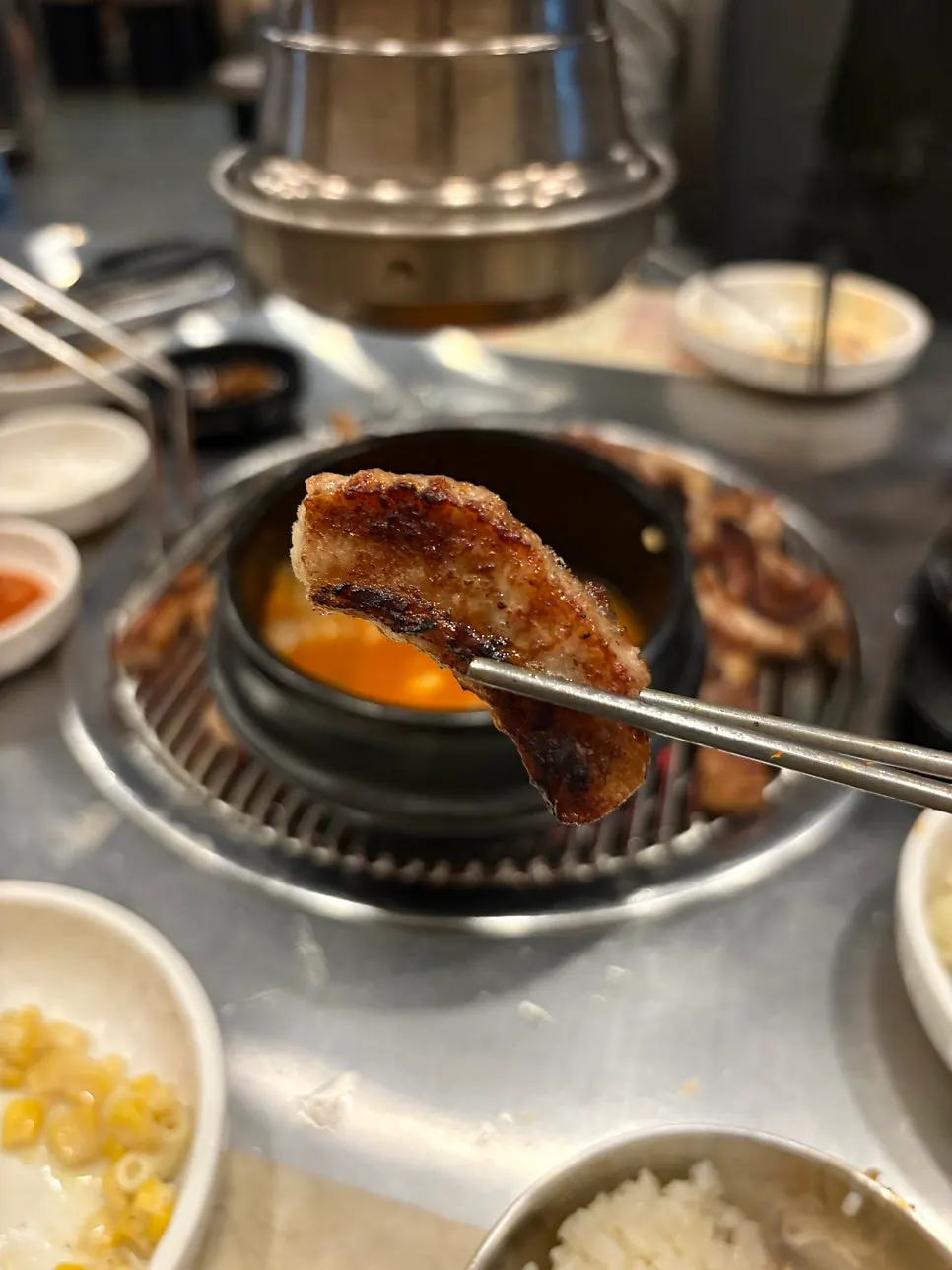 Pork jowl grilling on the grate