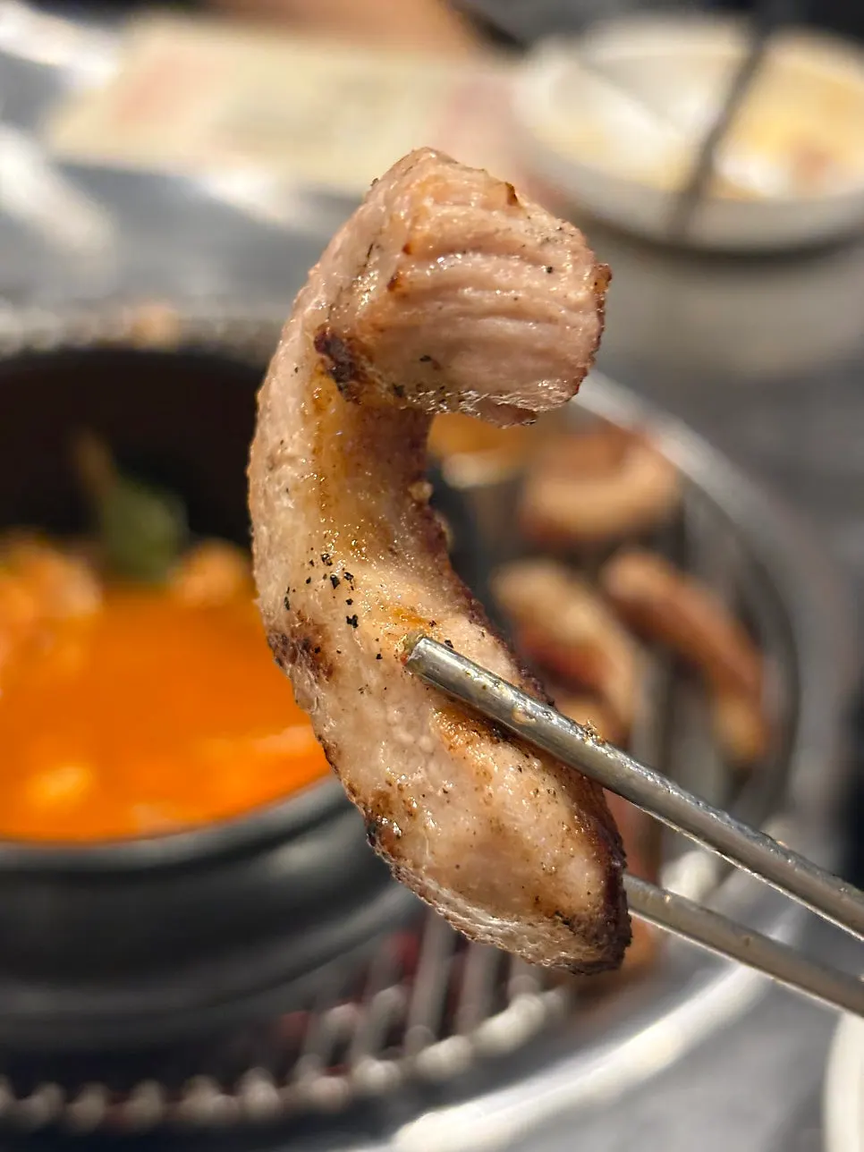 Pork belly and pork jowl grilling together on the grate