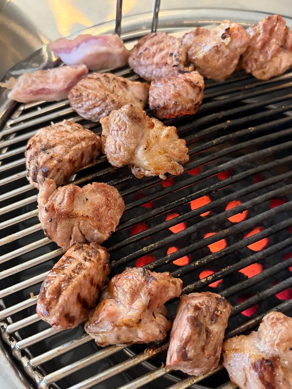 Close-up of pork neck over charcoal