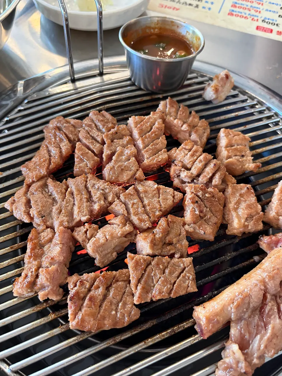 Grilling marinated giant pork skewer over charcoal