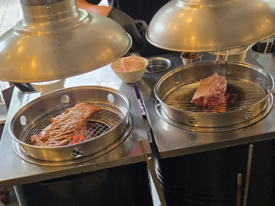 Table spread with the ordered two servings of marinated pork king grill