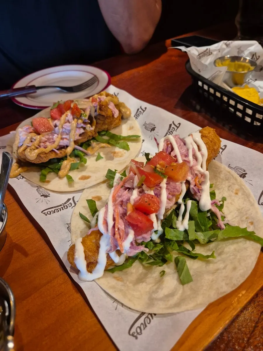 A plate with chicken taco and fish taco