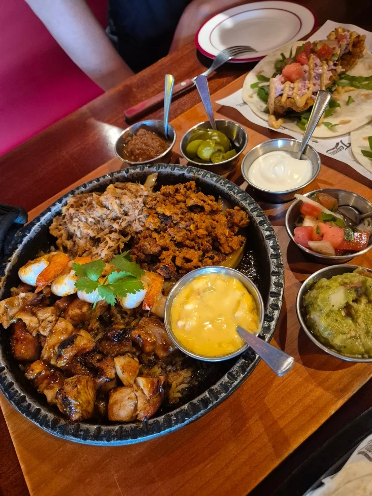 Fajita pan topped with pork, chicken, and shrimp