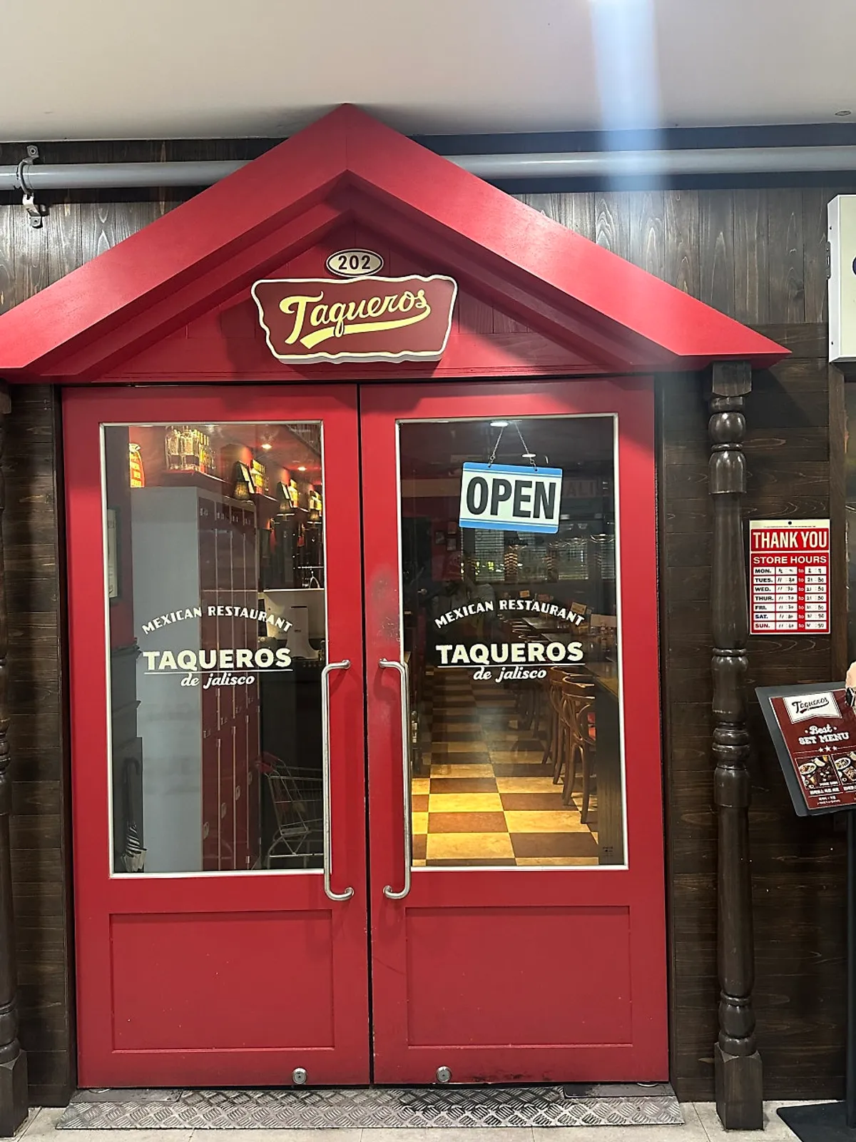 빨간 문과 TAQUEROS 간판이 있는 매장 입구