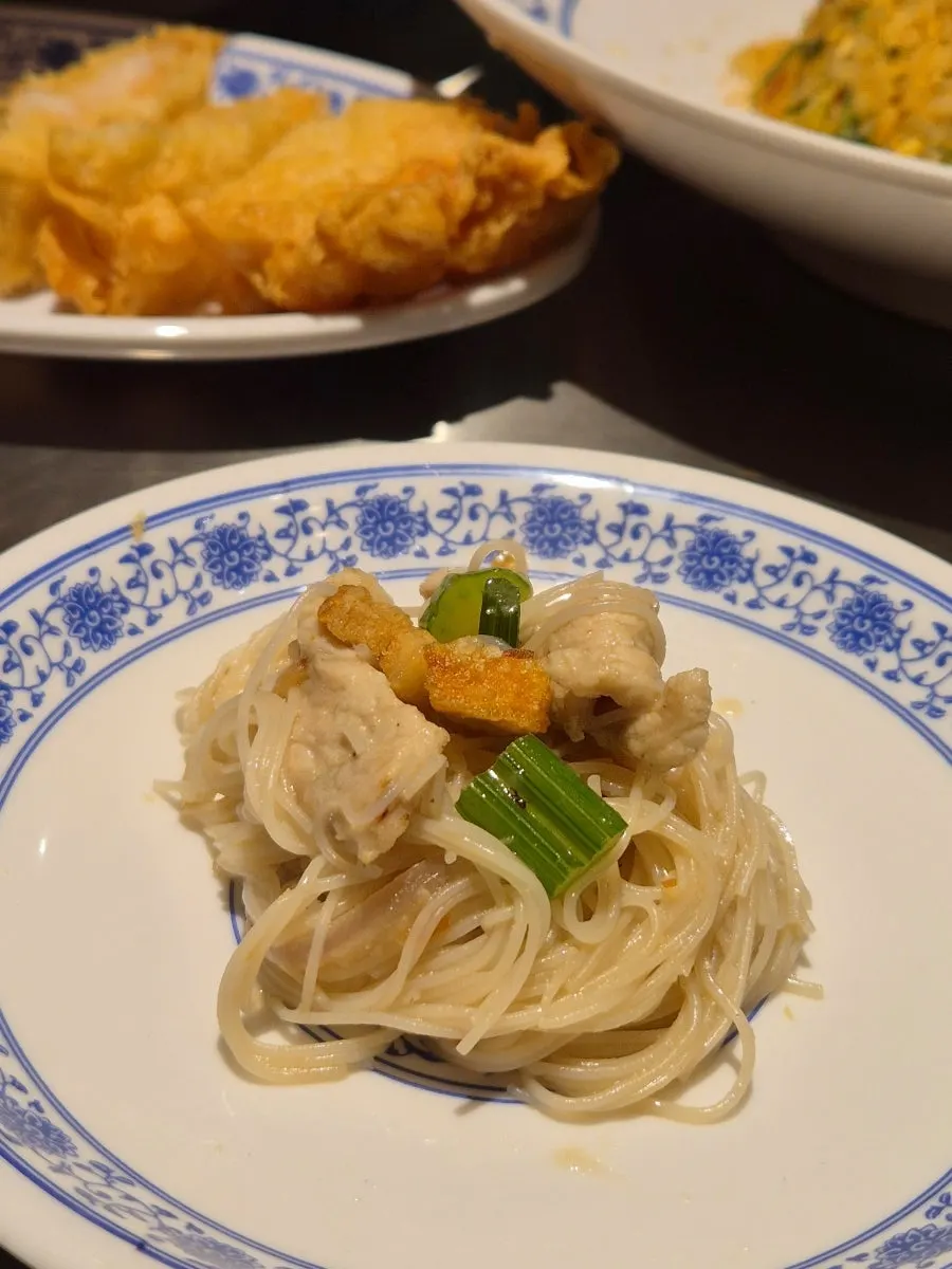 Lifting up a forkful of shrimp broth fried noodles