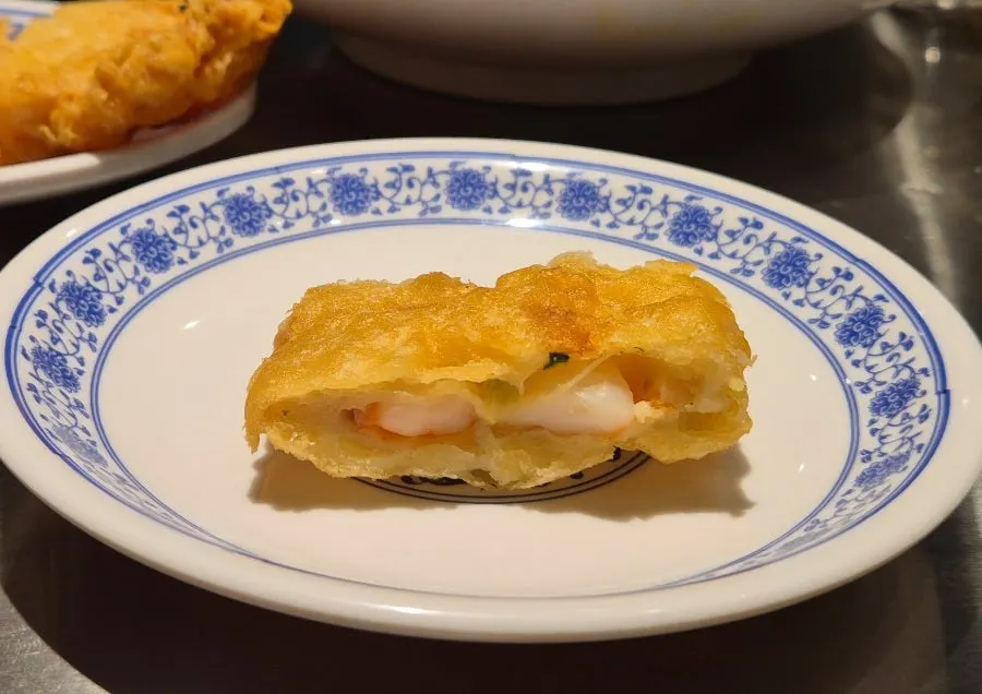 Cross-section of a fried shrimp roll packed with shrimp meat