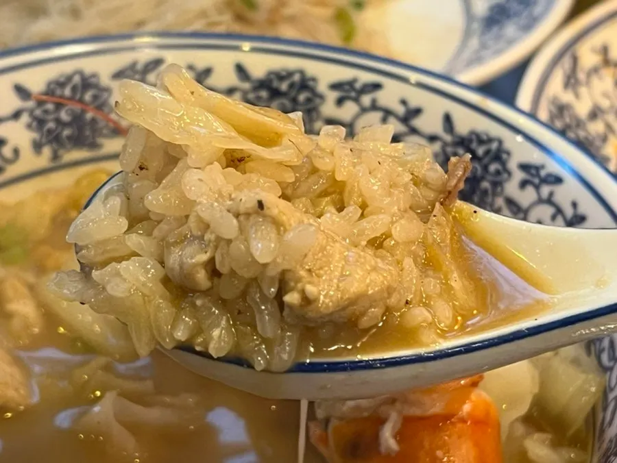 Rice soaked in broth with visible vegetables and meat in the shrimp gukbap