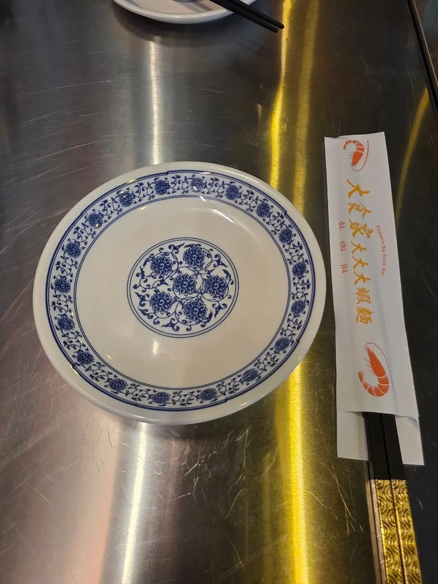 파란 무늬 그릇과 태블릿이 놓인 테이블 세팅