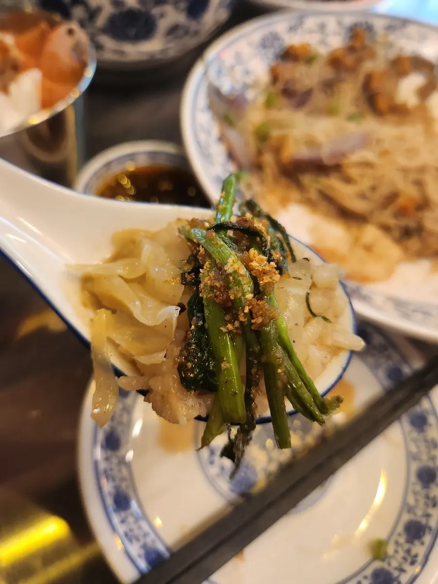 A spoonful of shrimp gukbap topped with sambal sauce