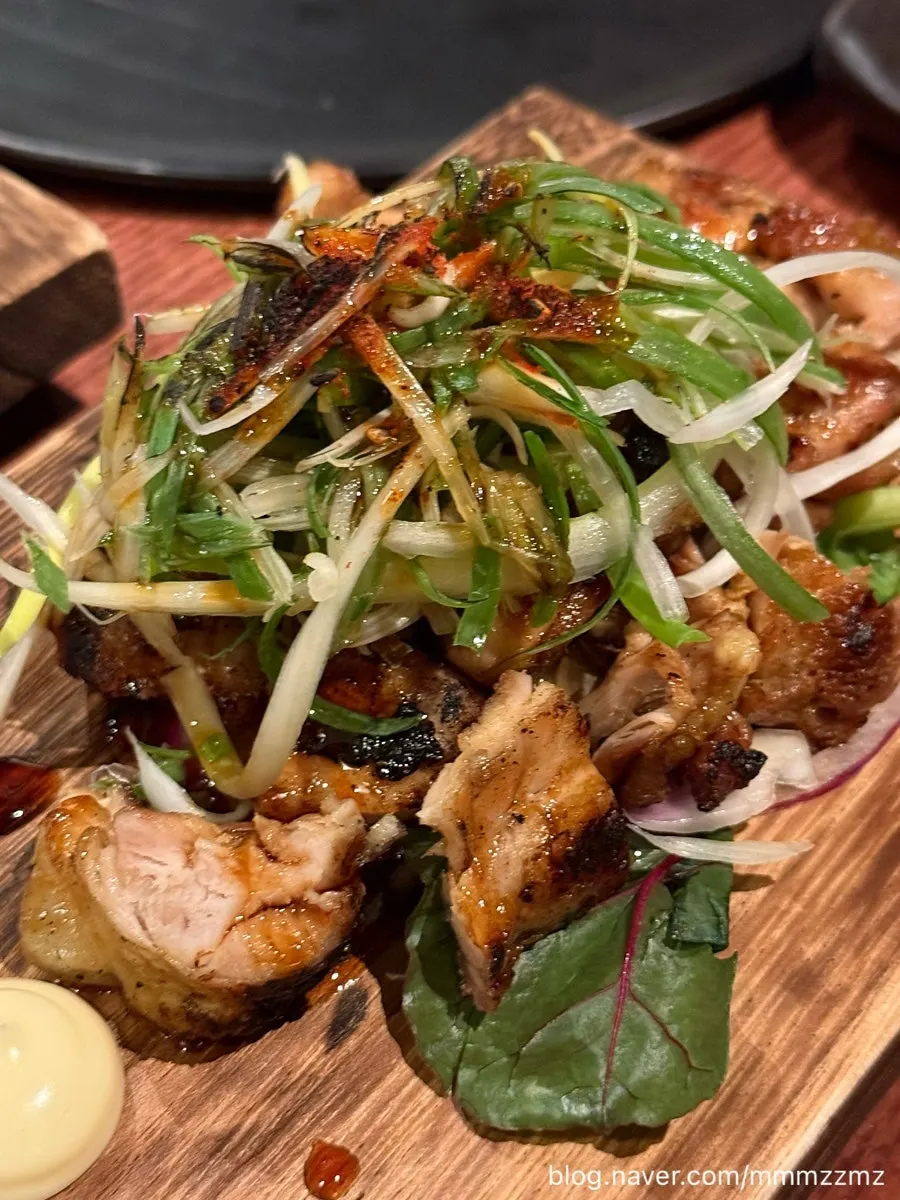 Dipping charcoal-grilled chicken thigh in mayo sauce