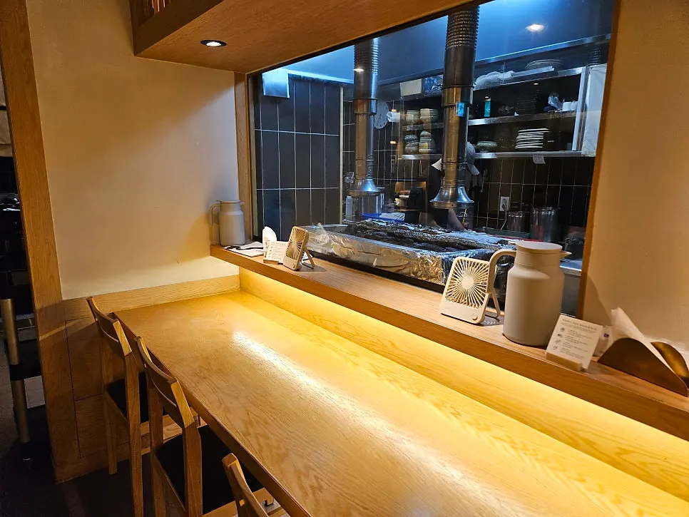 Tawa's bar seats with a view toward the kitchen