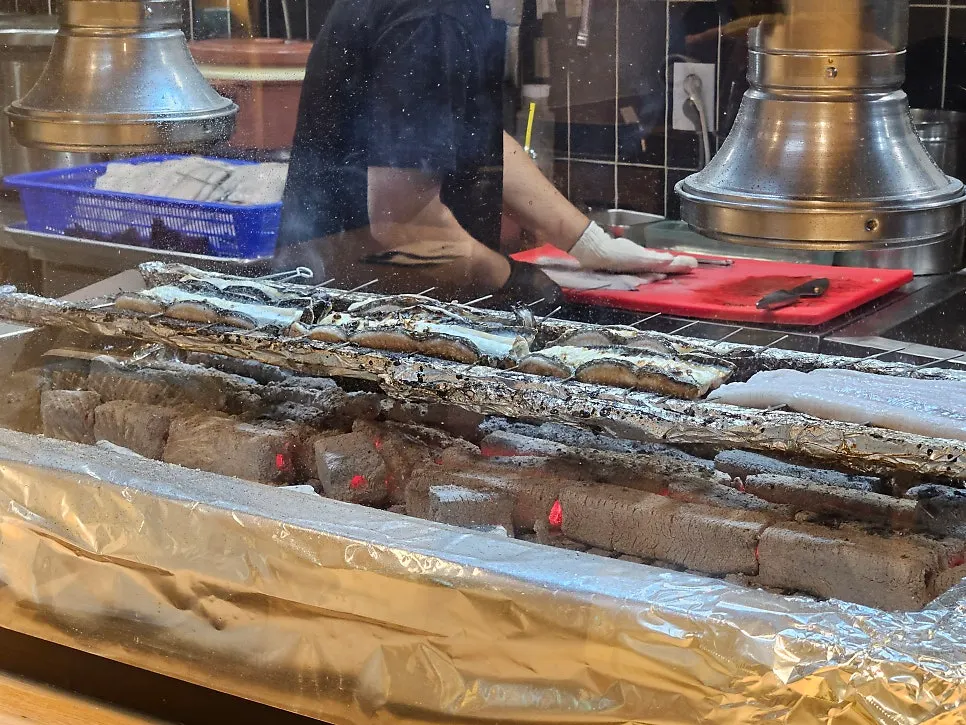 Bar seating with a view of eel being grilled
