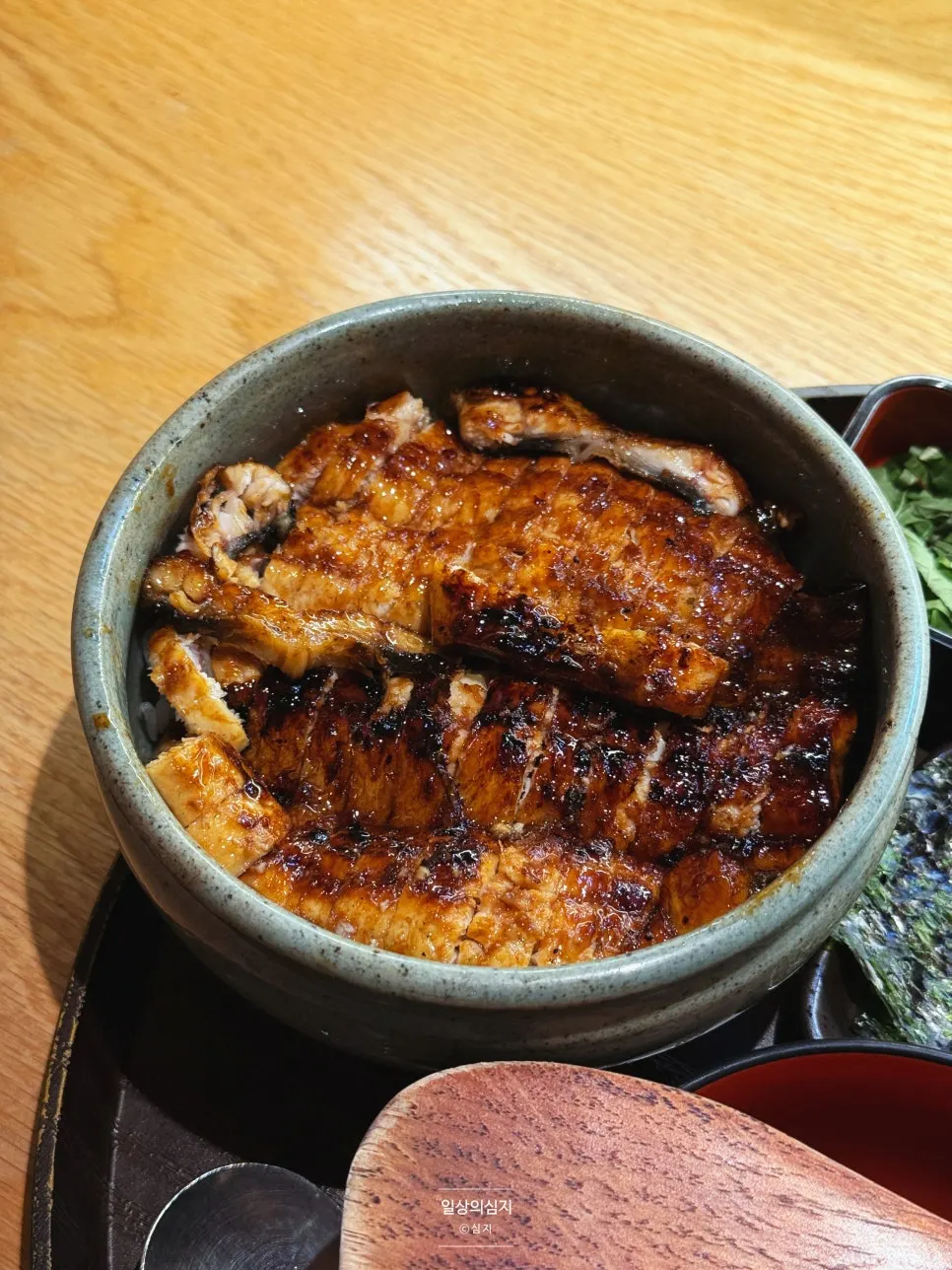 Eel rice bowl with lid opened next to hot soup