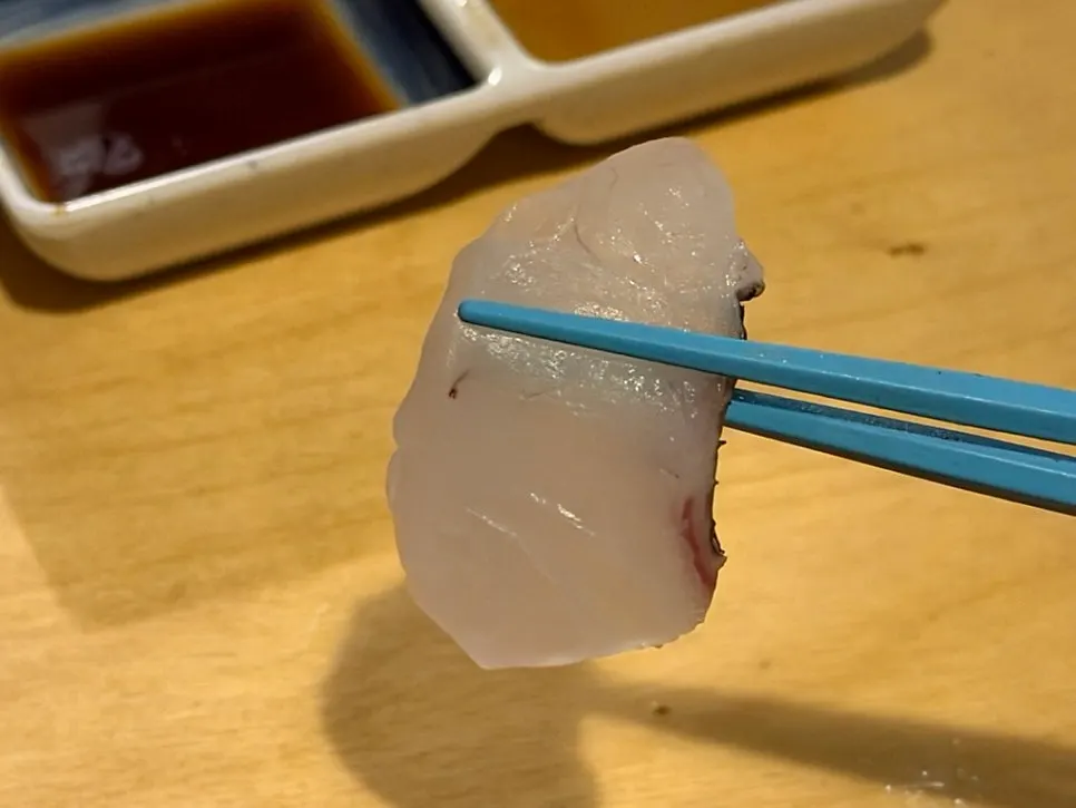 A piece of sashimi paired with warm sake