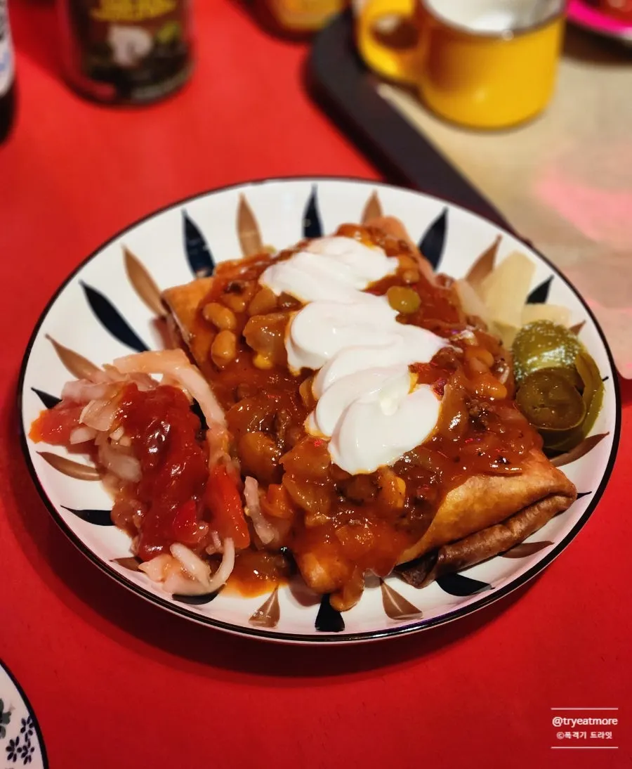 A cross-section of the chimichanga with chili sour cream sauce