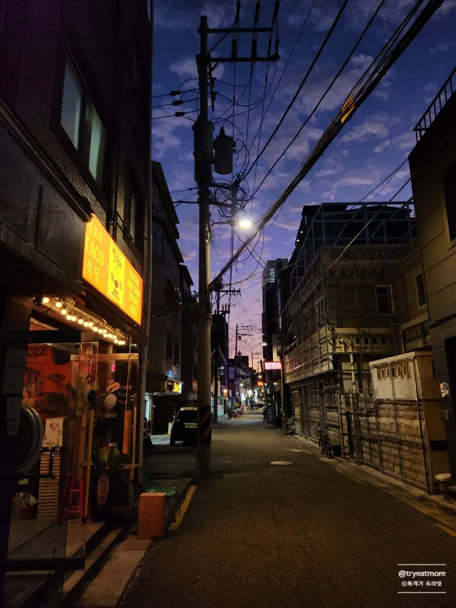 Teolbone Taco lit up at night in a Konkuk back alley