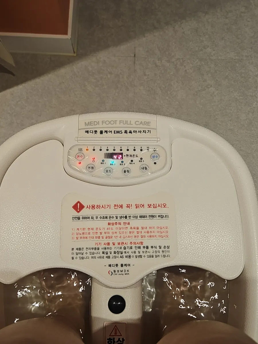 Feet soaking in warm water during the EMS foot spa