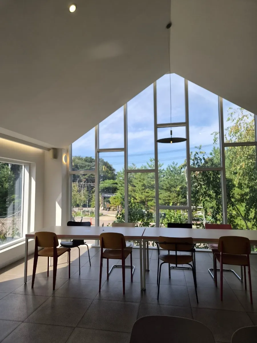 Second-floor space with sunlight through the window wall