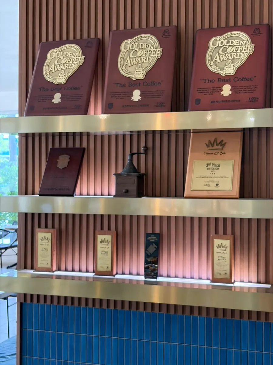 Coffee competition trophies filling a 1st-floor wall