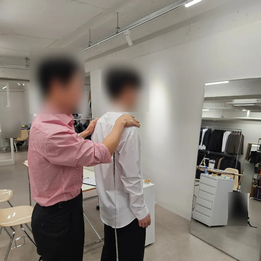 샘플 셔츠를 입고 핏을 확인하는 모습