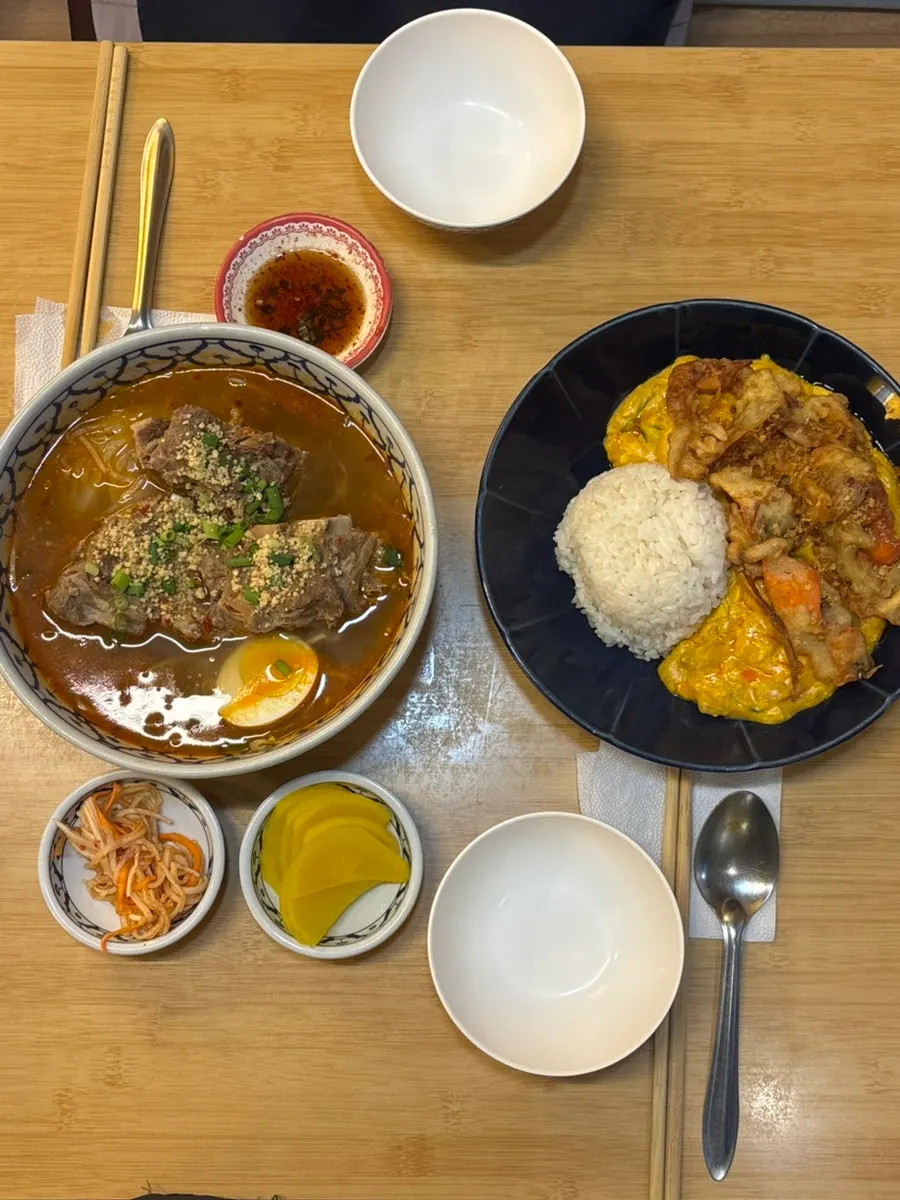 Two bowls of Thai dishes set on the table at Thanon55