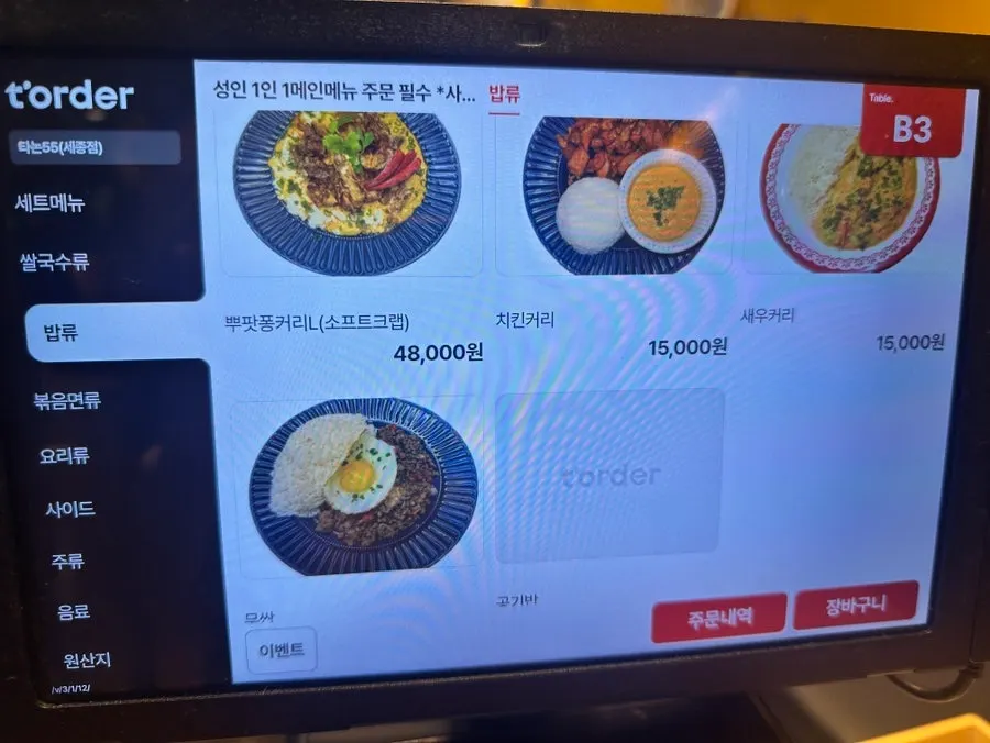 Menu board listing pad thai and curry dishes at Thanon55