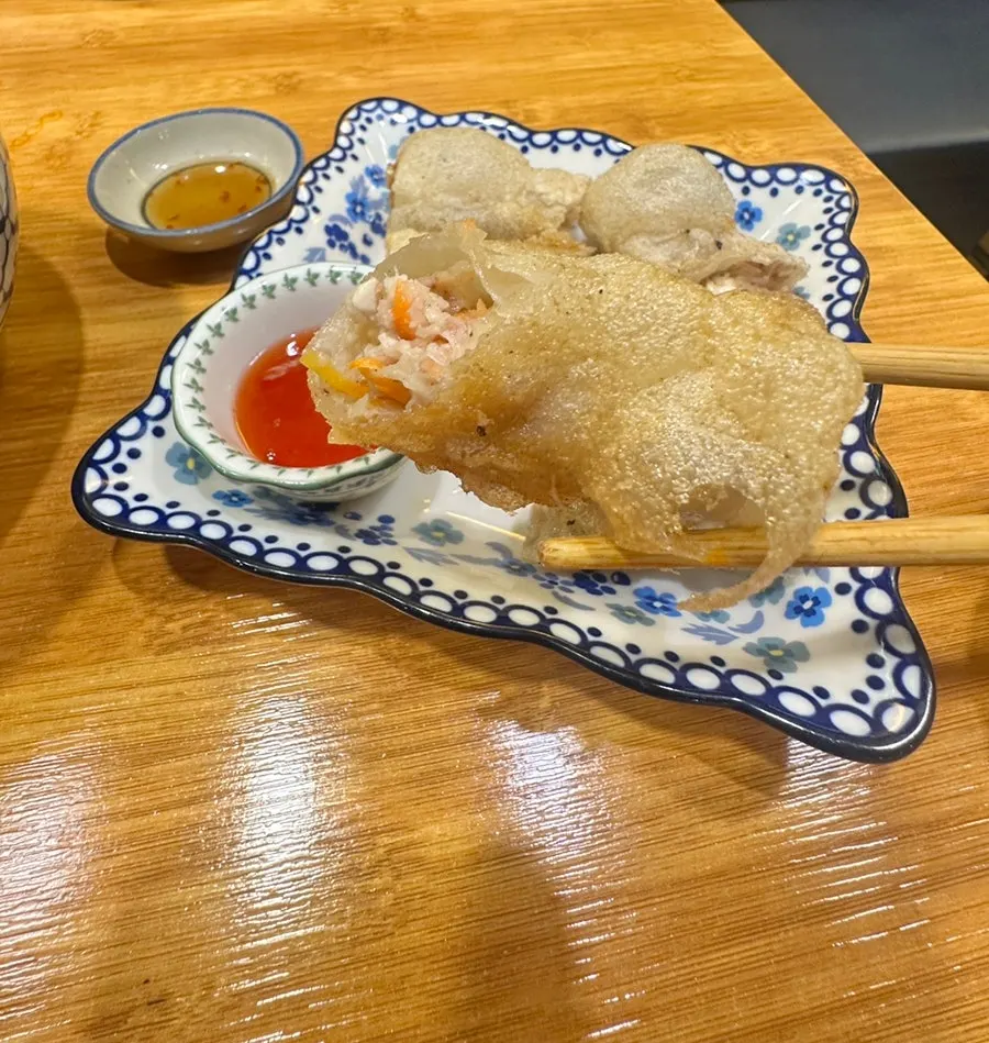 Cross-section of a spring roll dipped in chili sauce