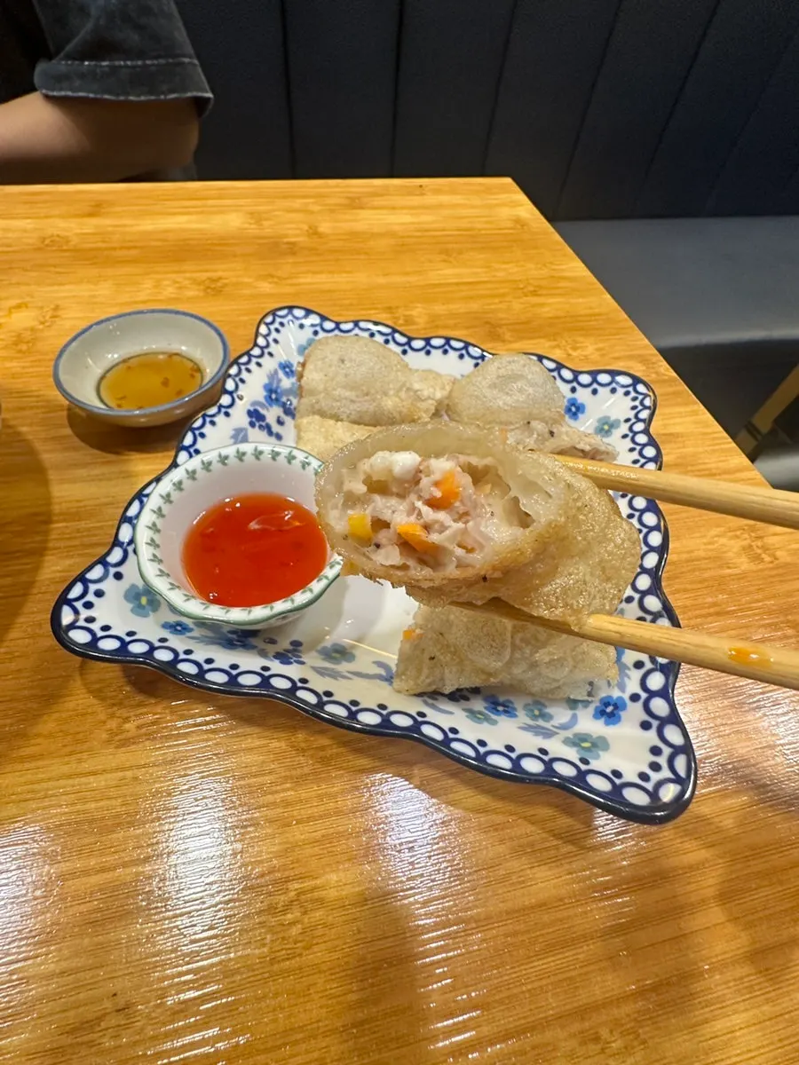 A spread of pork bone rice noodle soup, pork cutlet curry, and spring rolls