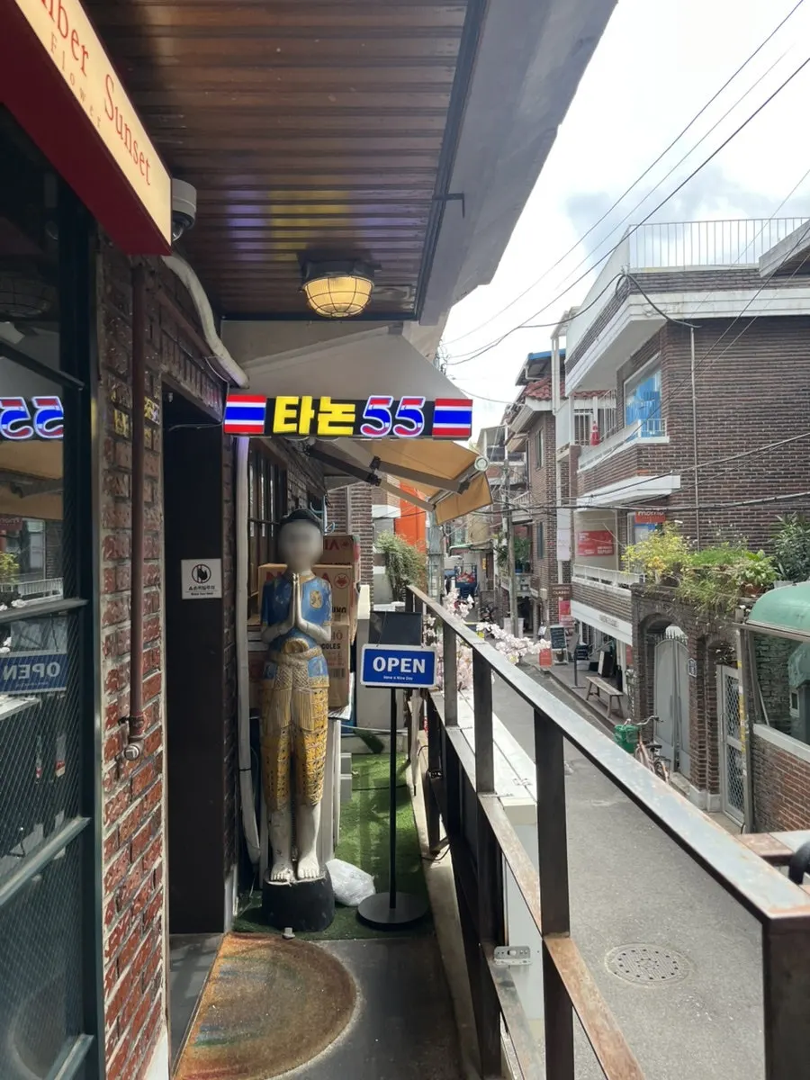 Second-floor sign for Thanon55 featuring the Thai flag