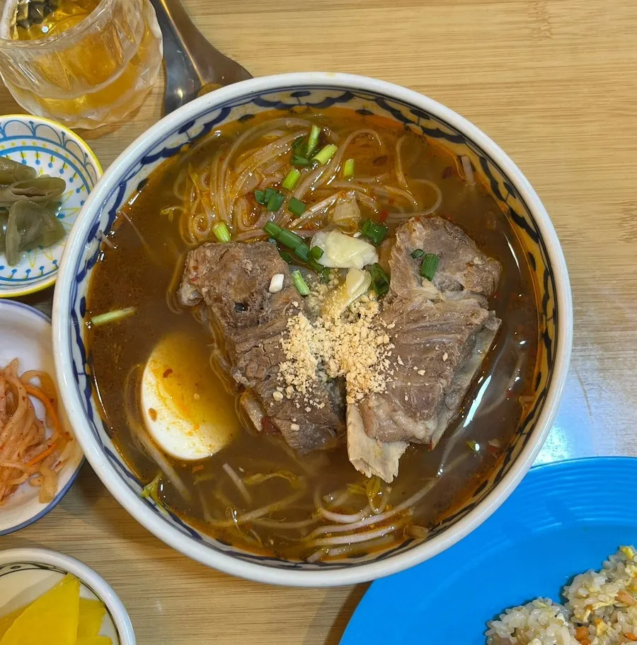 Gamjatang rice noodle soup with two pork spine bones on top