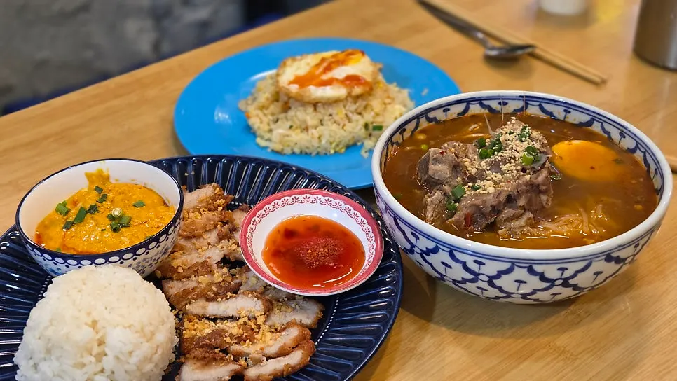A full spread of Thai dishes on a table at Thanon55