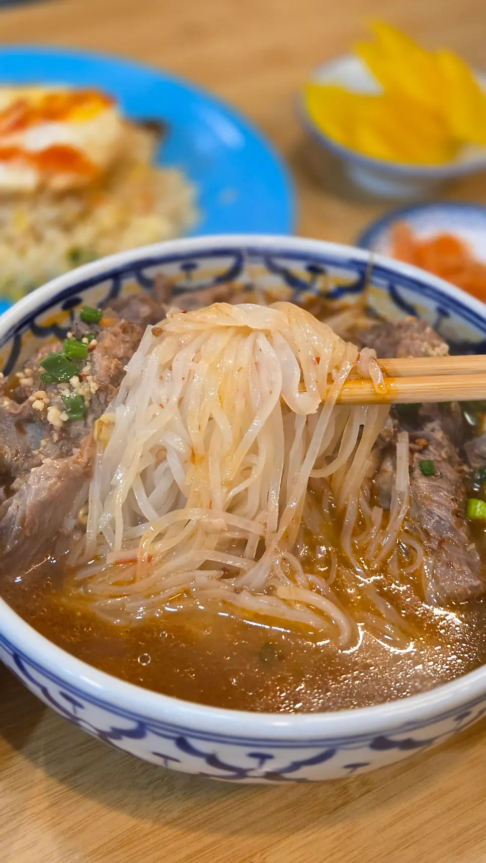 Picking the pork-bone meat off the bone in the gamjatang pho