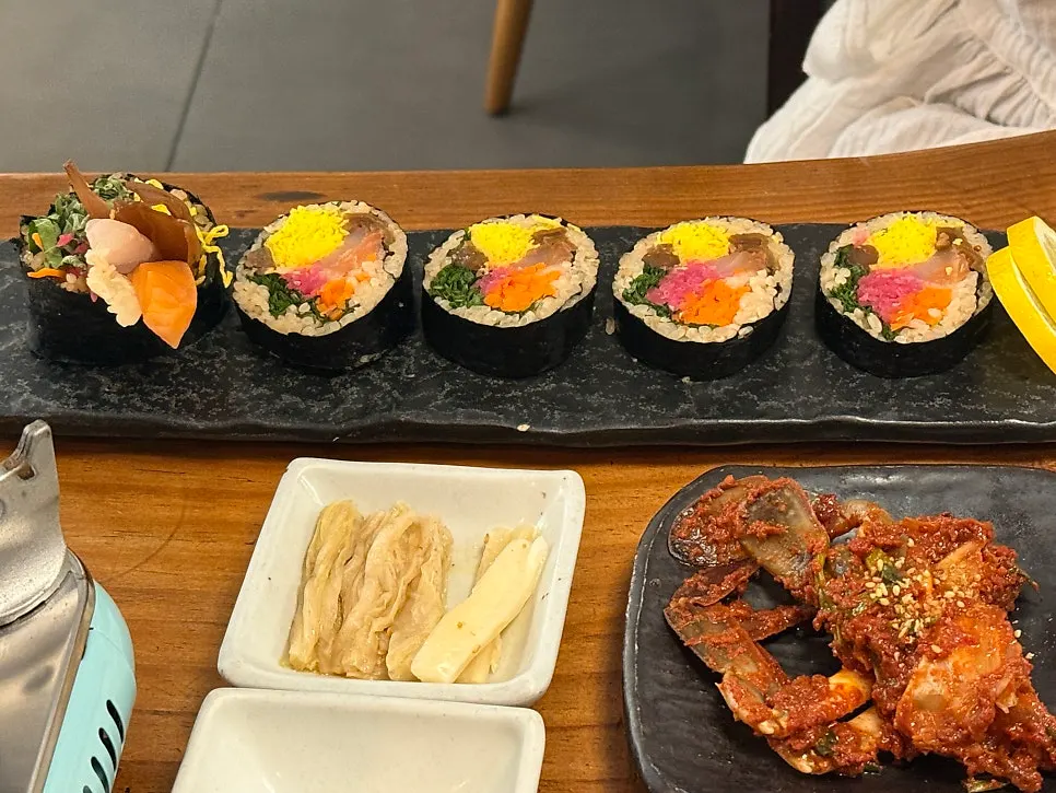Set composition with gimbap varieties, seafood, and seasoned vegetables