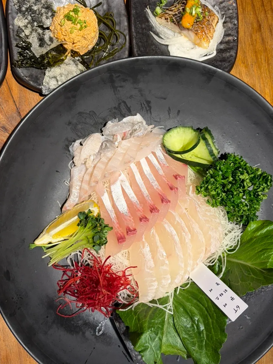 Table spread with sashimi and aged kimchi