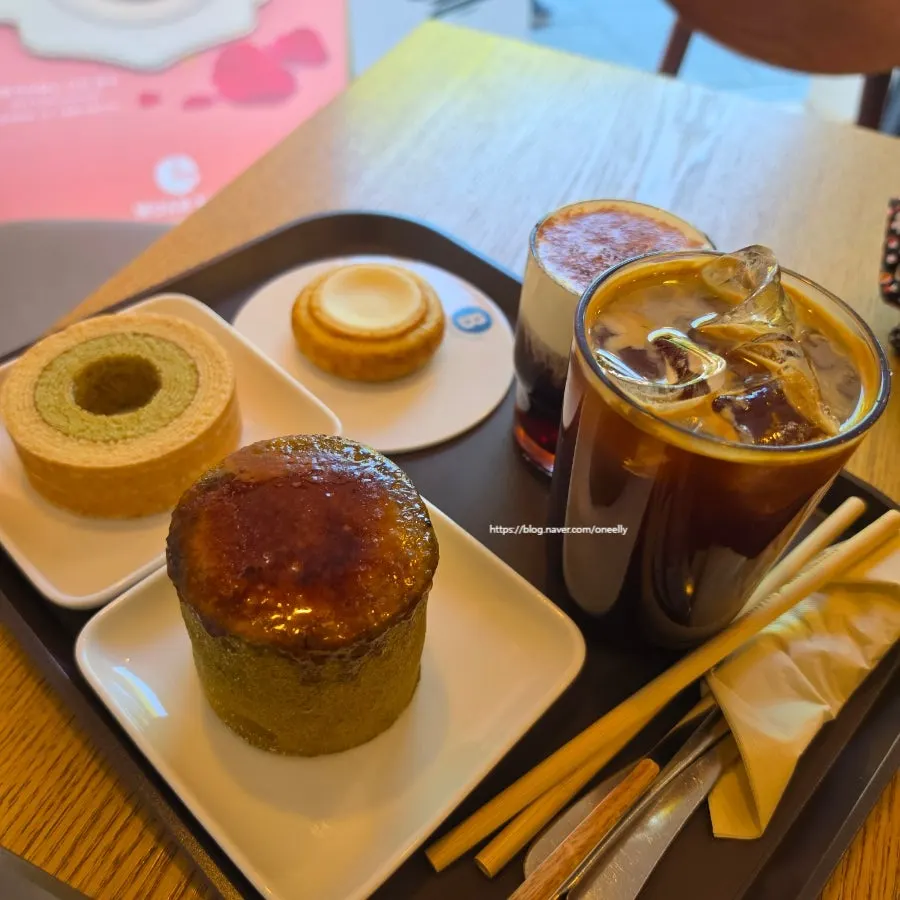 Table spread of brûlée matcha baum, cheese baum, and coffee