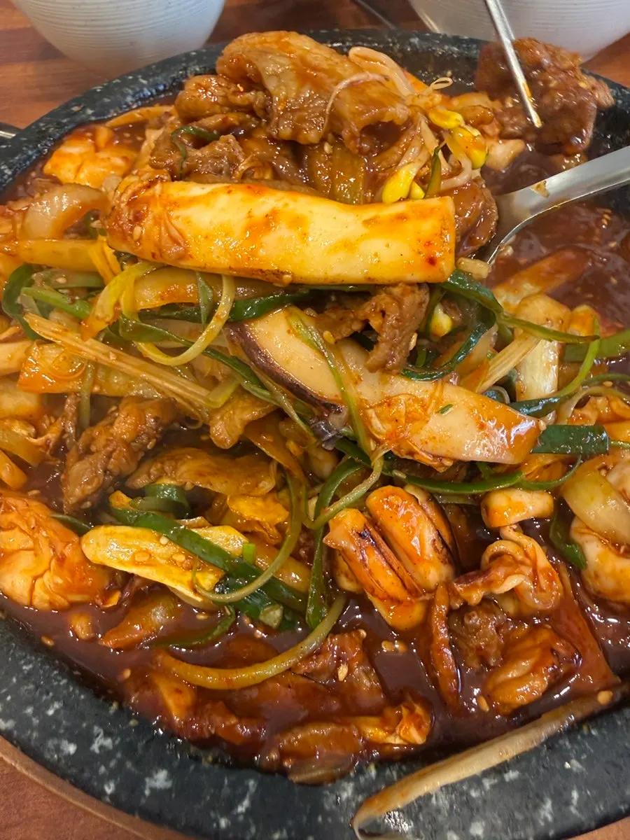 Fried rice being stir-fried on the stone plate