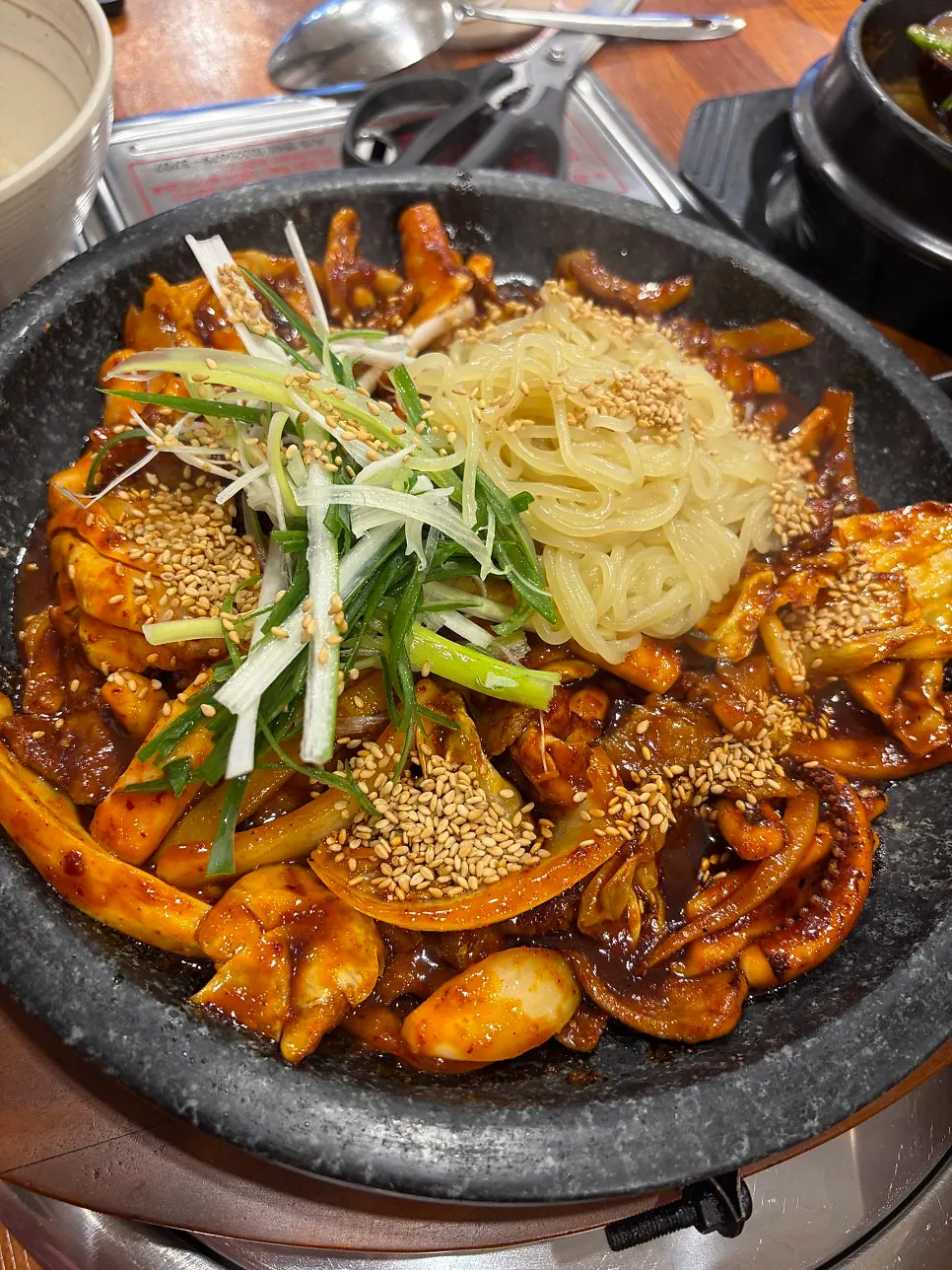 Sizzling hotplate oje bokkeum topped with green onion shreds and jjolmyeon