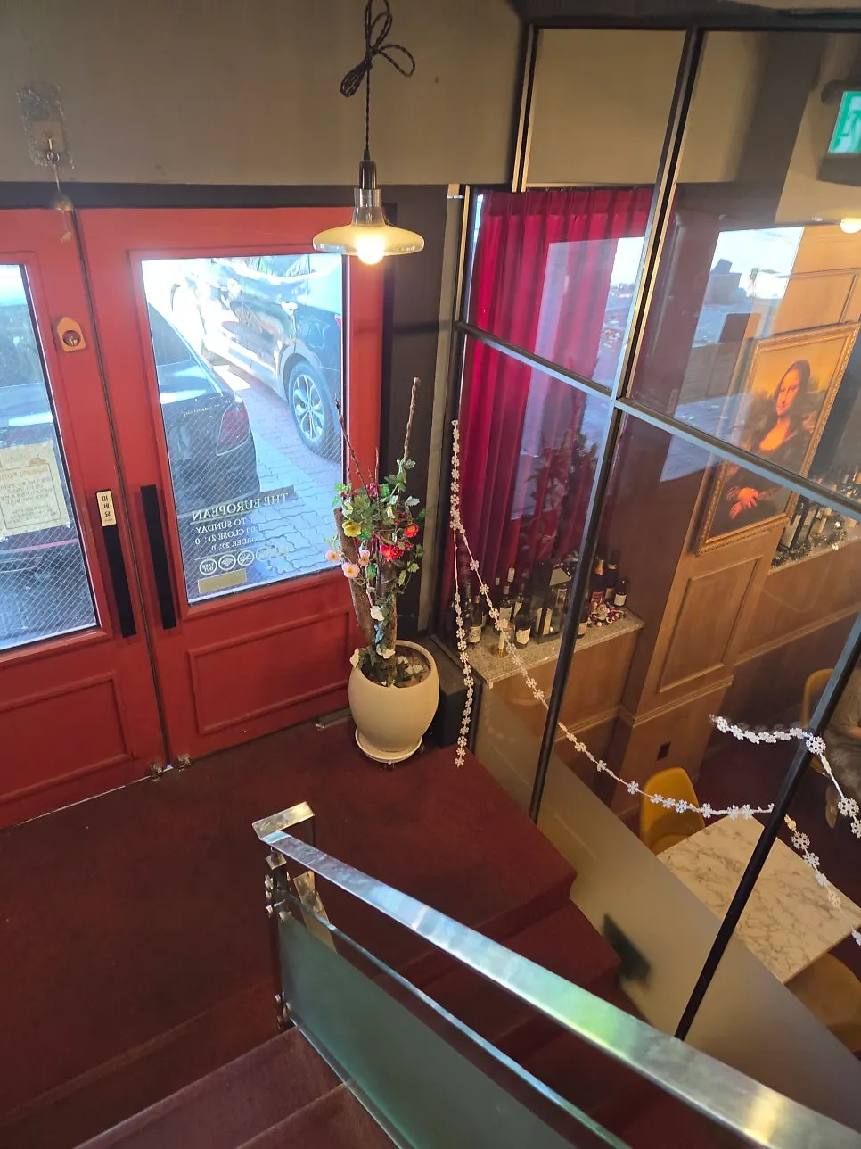 Staircase to the second floor lined with a red carpet