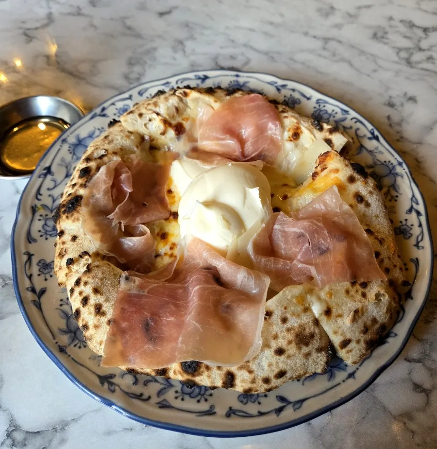 Quattro formaggi hamón wood-fired pizza served with honey