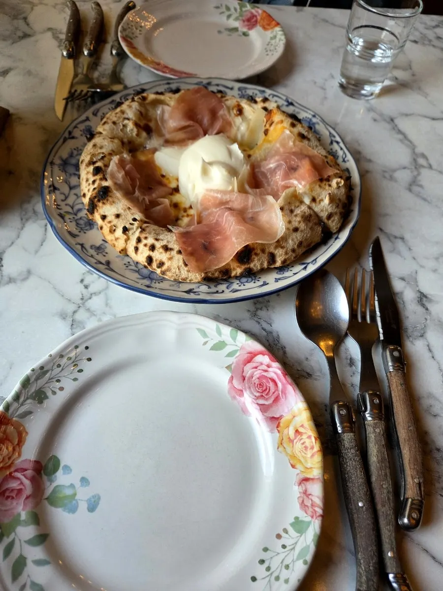 Slice of quattro formaggi hamón pizza loaded with toppings