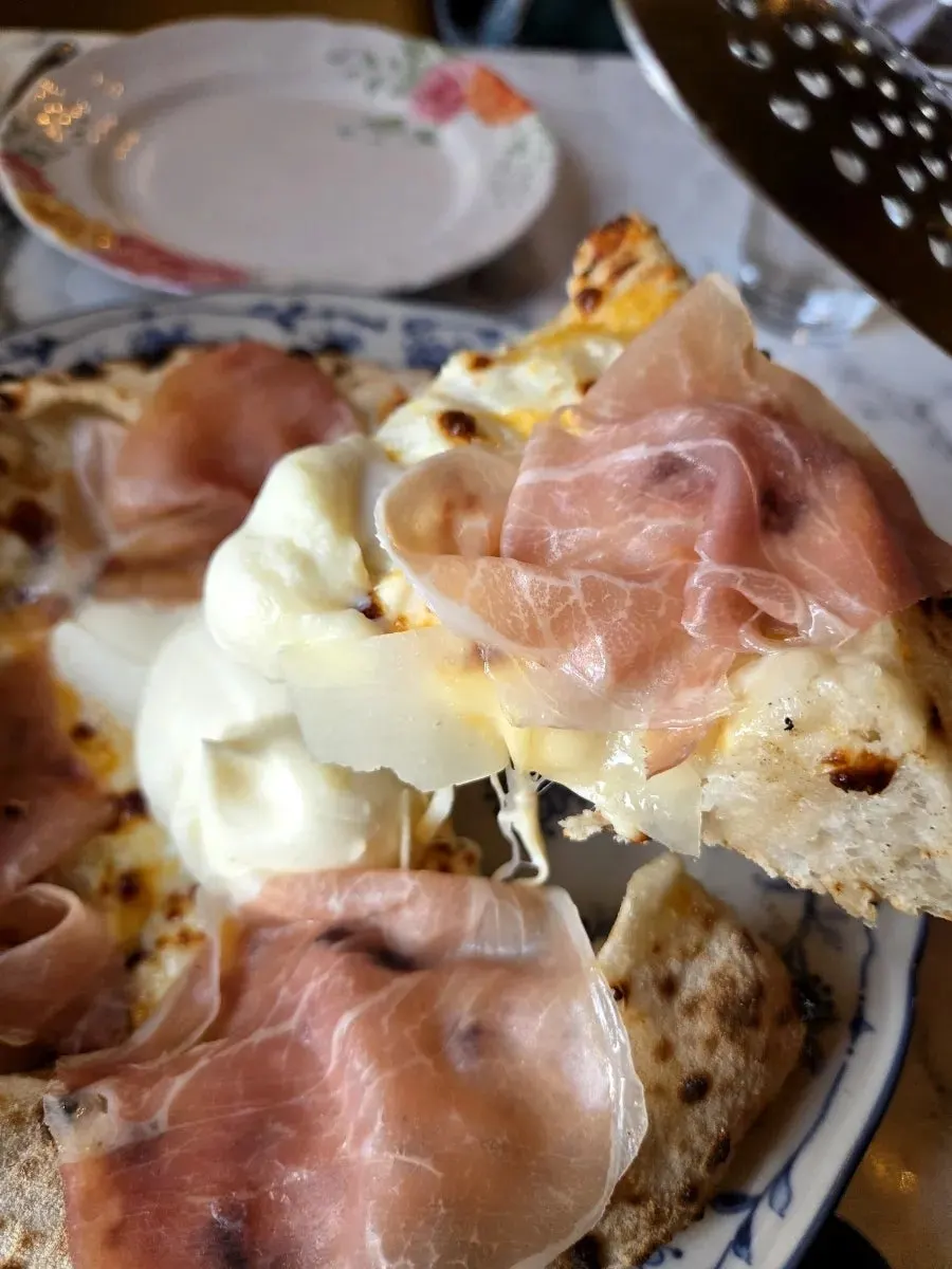 Wood-fired pizza slice with stretchy mozzarella cheese