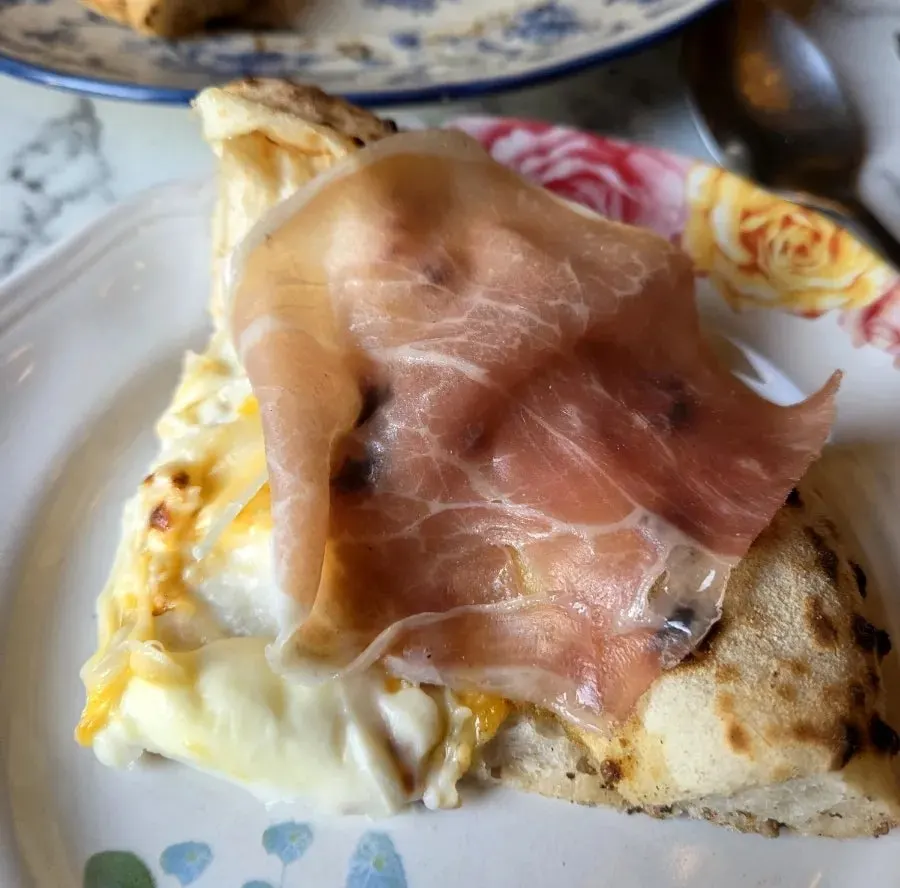 Quattro formaggi pizza topped with hamón