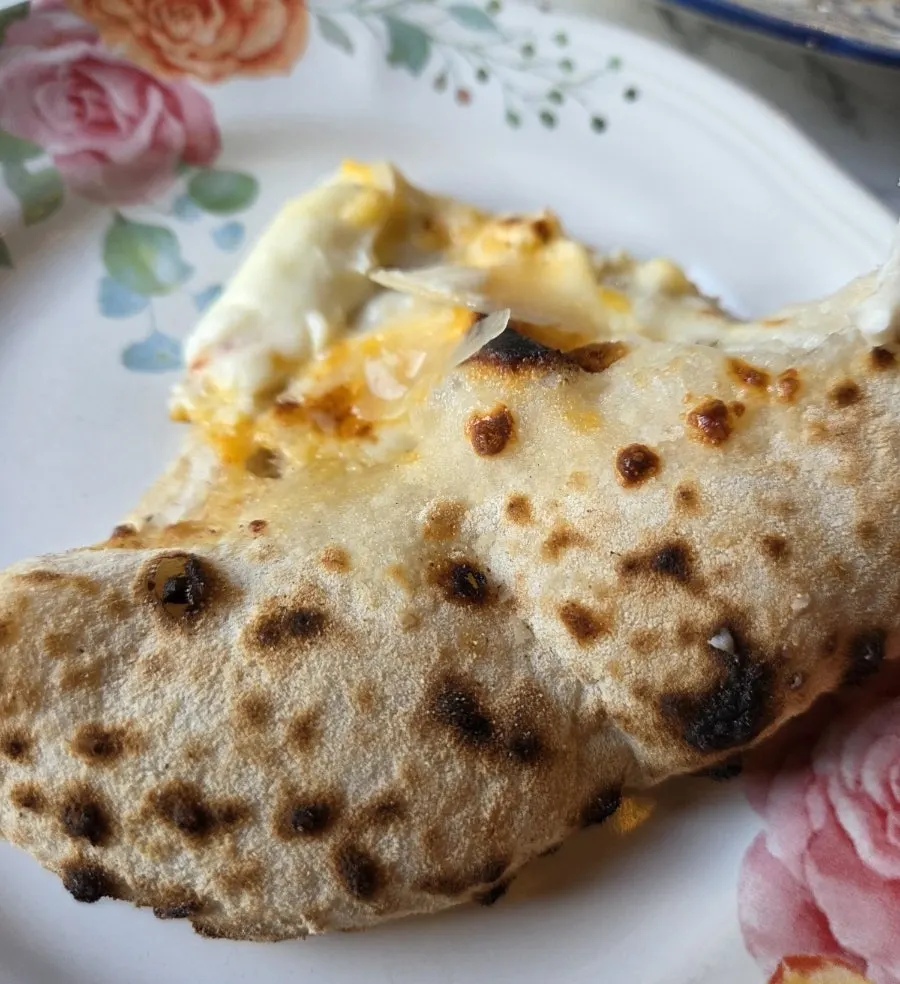 Dipping the wood-fired pizza crust end into honey