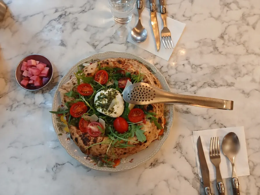 Rocket burrata pizza served at the table