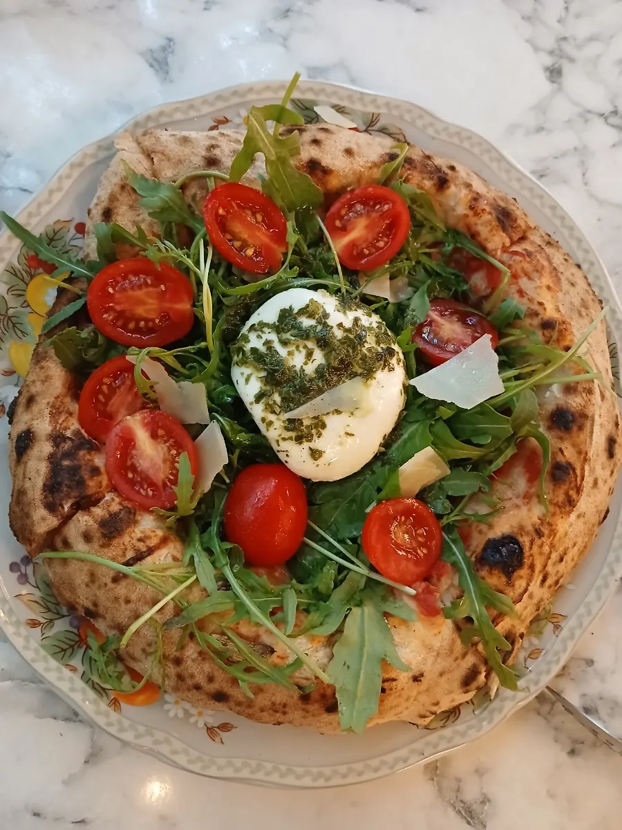 Wood-fired pizza piled high with rocket