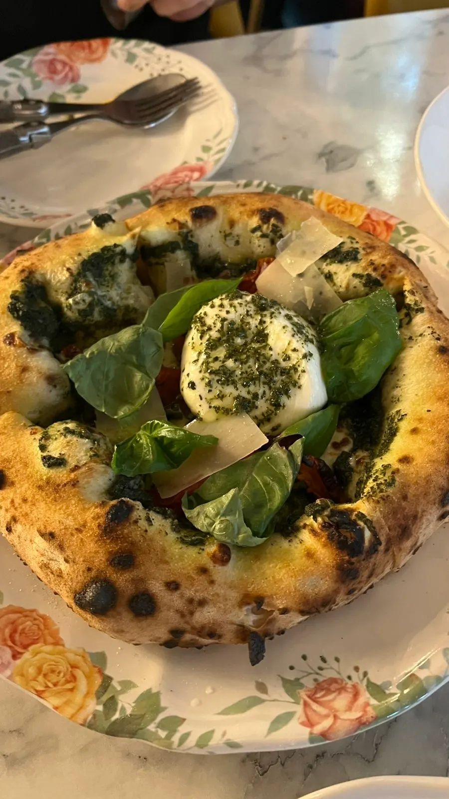 Pizza topped with burrata cheese and basil leaves