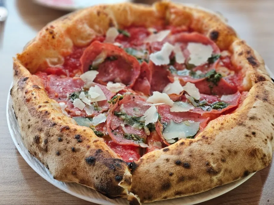 Wood-fired Genoa salami pizza with a puffed crust edge