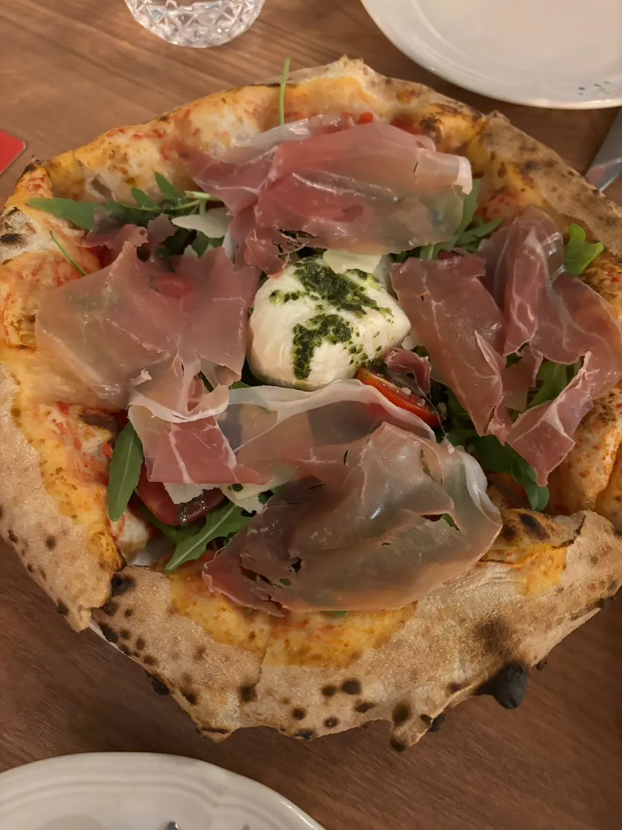 A whole signature arugula jamón burrata pizza