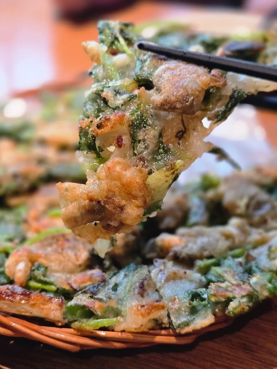 A piece of cockle and water parsley pancake lifted up