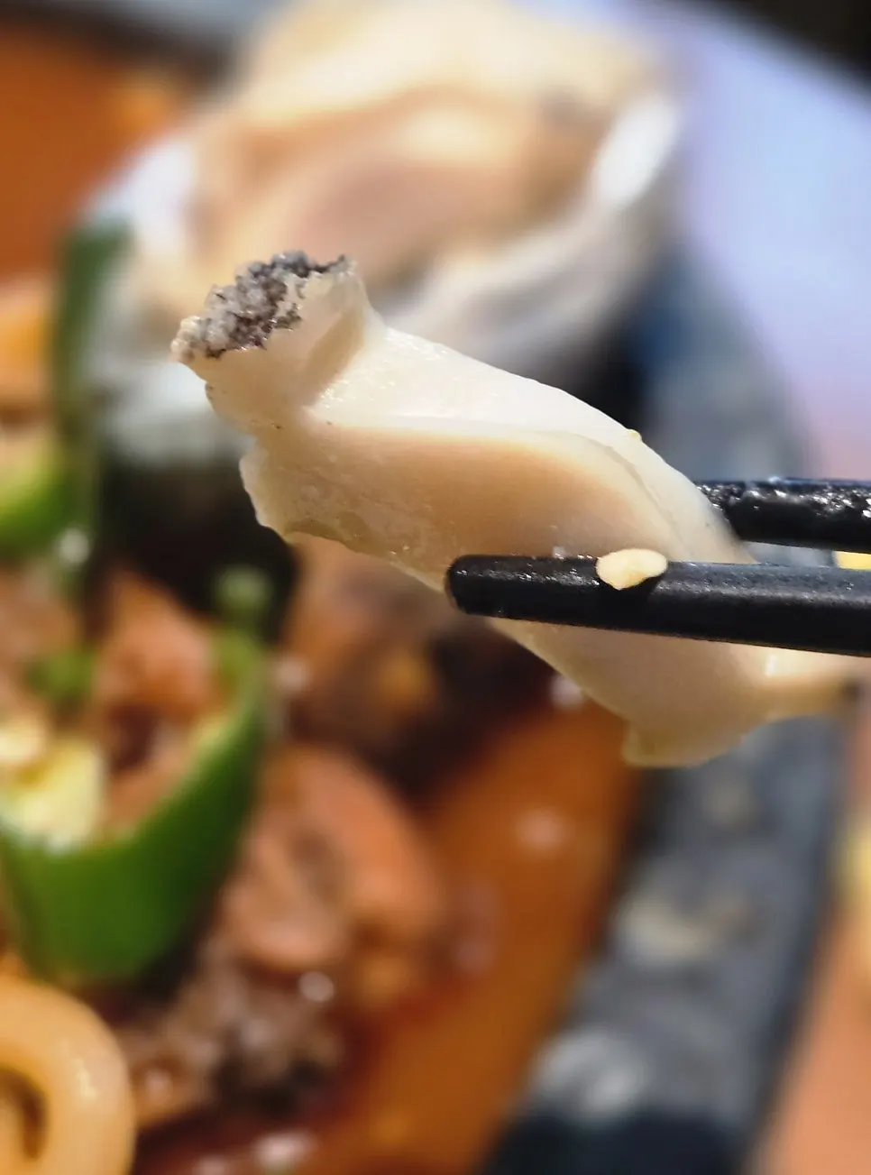 A piece of abalone dipped in the sauce